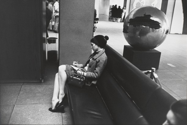 Untitled (Woman seated on black couch, in dark suit, writing)